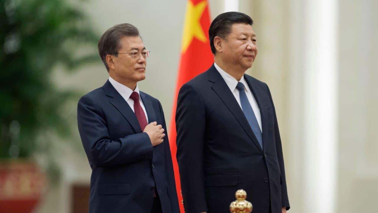South Korean President Moon Jae-In (L ) and Chinese President Xi Jinping (R) listen to the South Korean anthem at the Great Hall of the People.