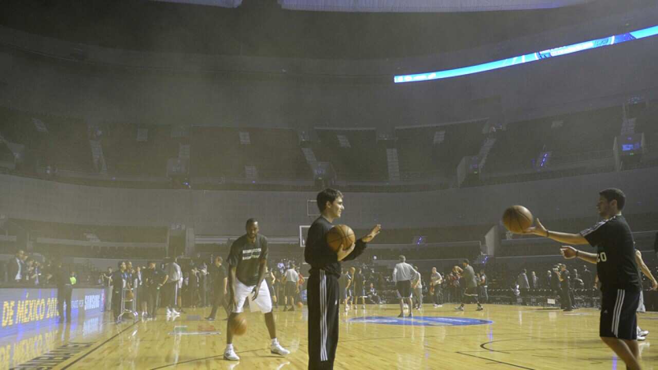 NBA players warm up at the smoke-filled Arena Ciudad de Mexico