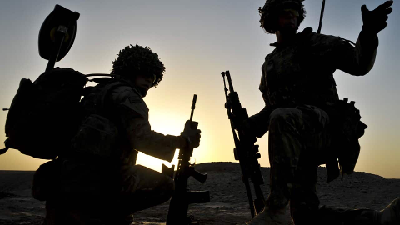The sun rising behind soldiers