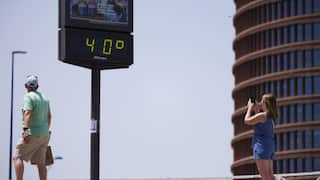 A woman takes pictures of a thermometer reading 40 degrees Celsius on June 21, 2026 in Seville, Spain.