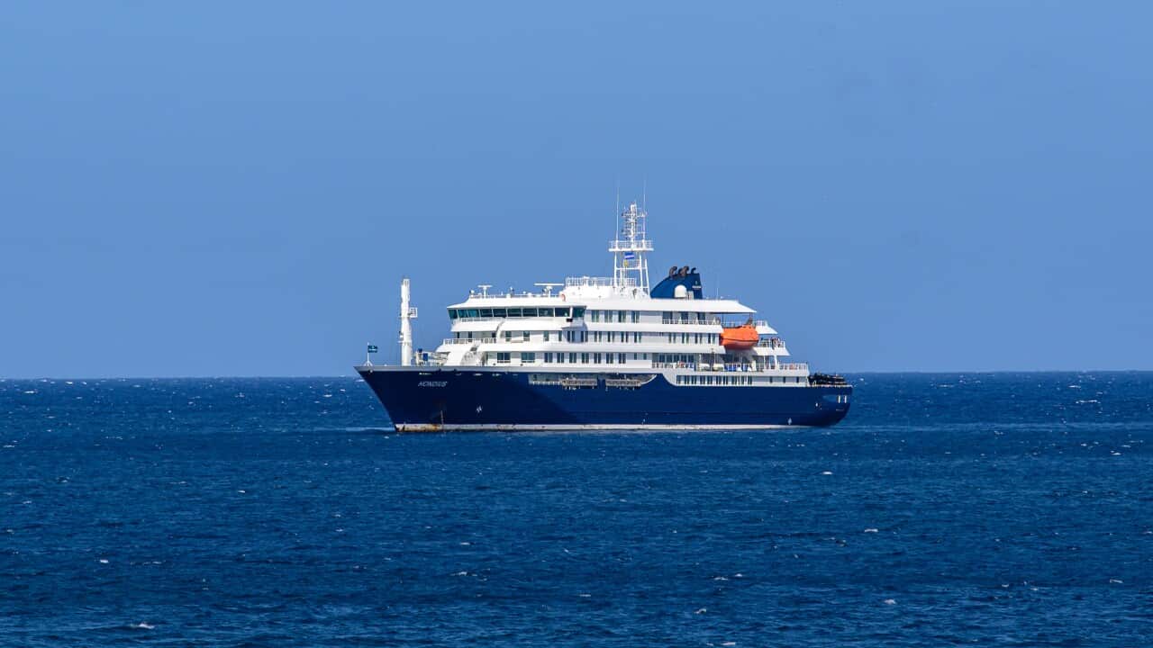 A small cruise ship with a blue hull out at a sea