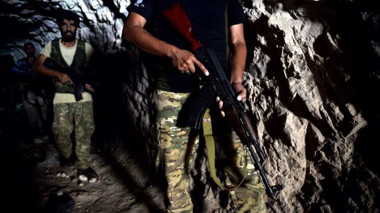 Fighters with the Free Syrian army leave a cave where they live, in the outskirts of the northern town of Jisr al-Shughur, Syria, west of Idlib.