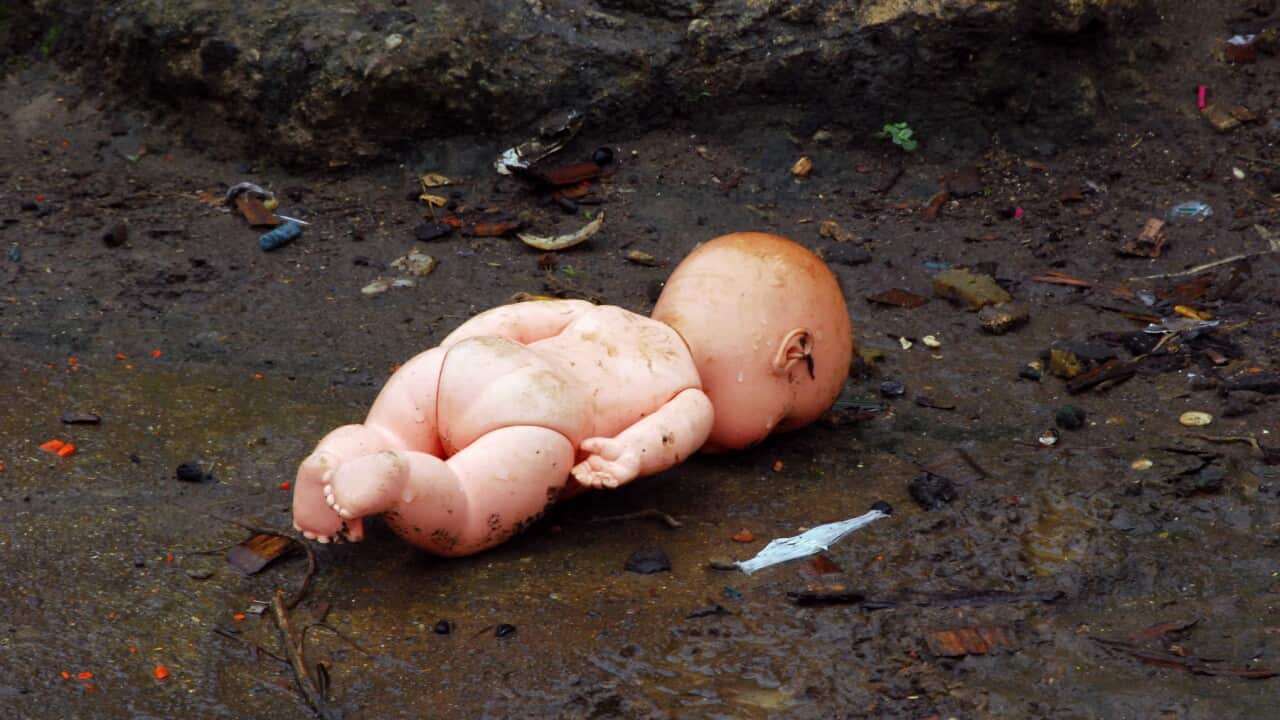 Doll thrown on the dirty floor.