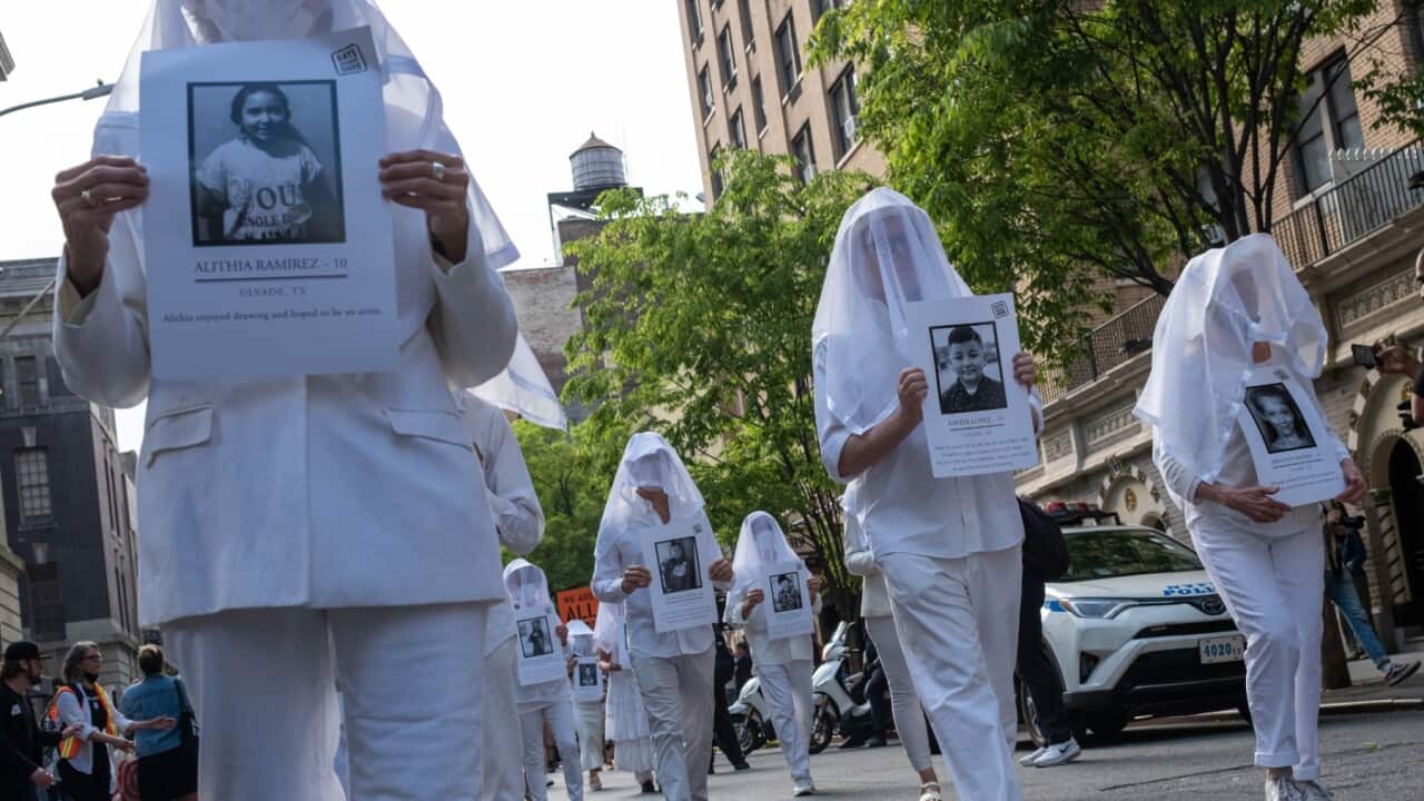 Gun-rights activists hold signs bearing the likenesses of the victims of the Texas elementary school mass shooting during the Gays Against Guns rally in Times Square on May 26, 2022 in New York City.