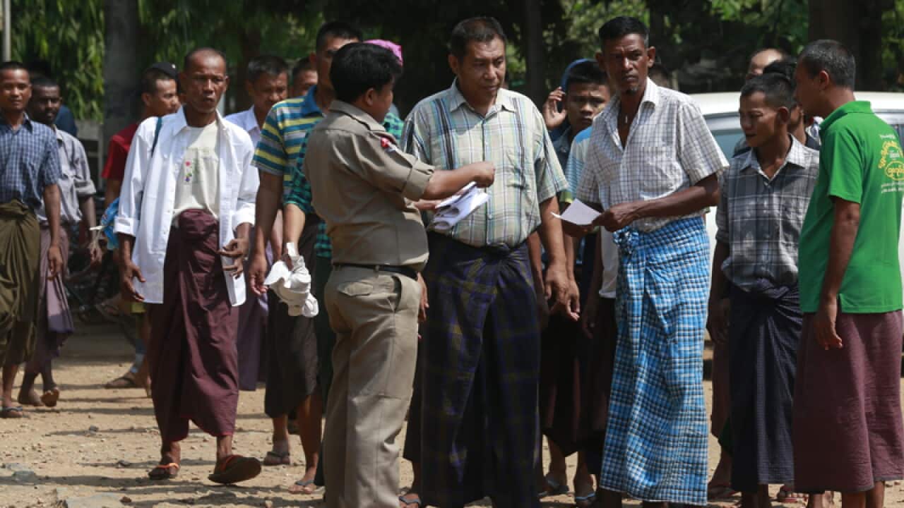 A prison officer gives release papers to prisoners