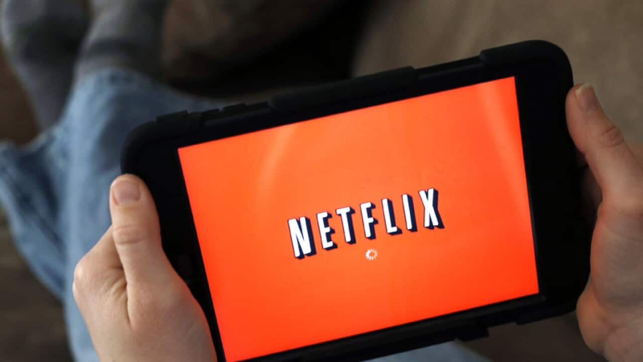 A person displays Netflix on a tablet