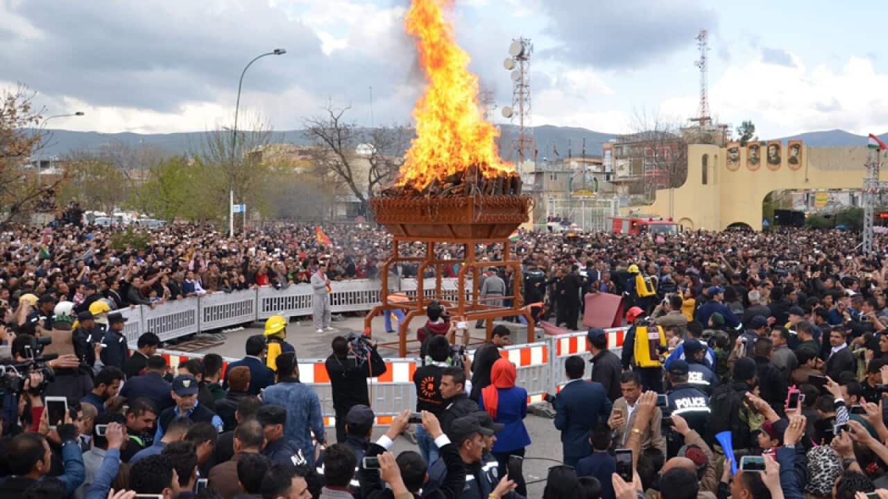 Iraqi Kurds gather near a fire as they celebrate the Persian New Year