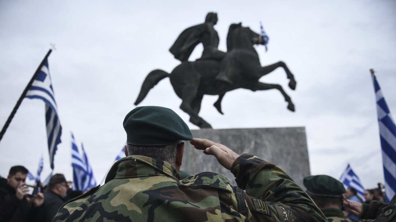 A Greek protester salutes a statue of Alexander the Great. (AAP)