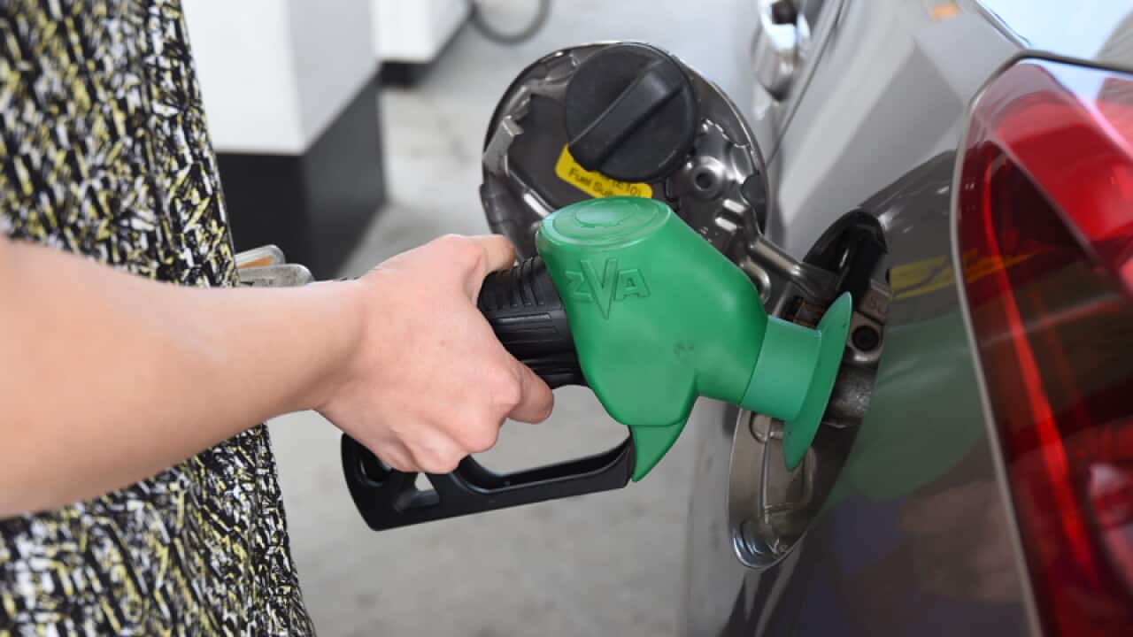 A motorist refuels her car at a petrol station