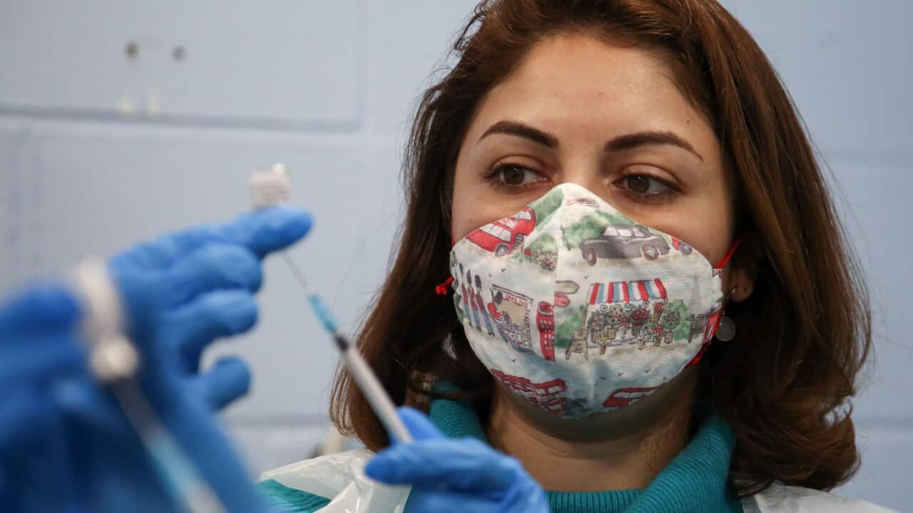 A healthcare worker preparing to administer a COVID-19 vaccination.