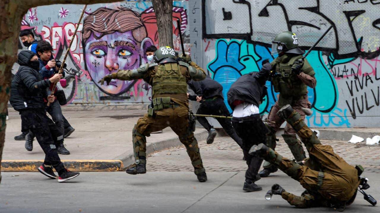 Riot policemen clash with demonstrators during a protest of Mapuche Indigenous people in downtown Santiago, on October 10, 2021.
