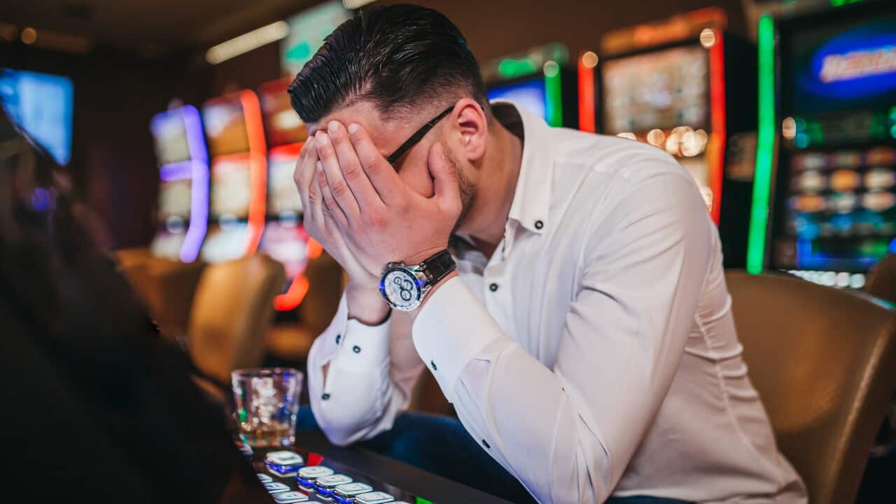 Young man loosing his money on slot machines
