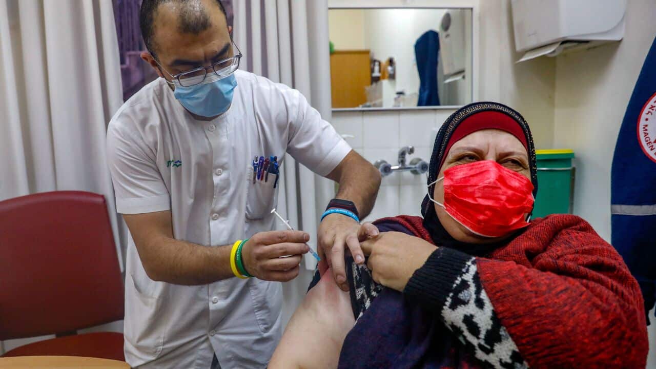 A Palestinian woman receives the Pfizer-BioNTech COVID-19 vaccine at the Clalit Health Services in the Israeli-annexed east Jerusalem, on 30 January 2021.