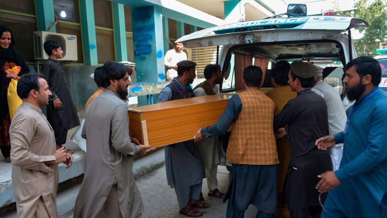 Relatives carry the coffin of a victim killed in the outside a mortuary in Jalalabad on October 21, 2020.