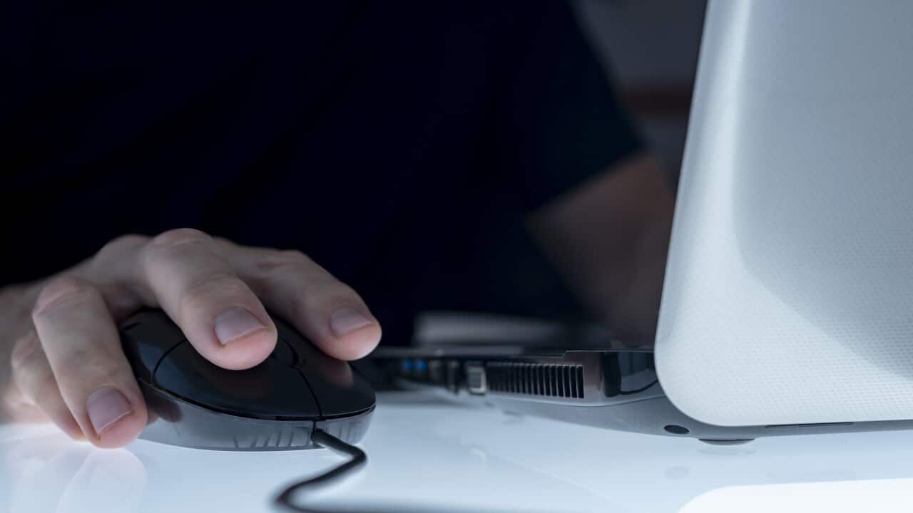 CLOSE UP OF A MALE HAND ON THE MOUSE USING LAPTOP ONLINE. TELECOMMUTING CONCEPT. CYBER BULLYING, PEDOPHILIA, PEDERASTY, GROOMING, HACKING ATTACK, VIRUS, MALWARE, SPYWARE, SPAM, SHOPPING ADDICTION AND OTHER RISKS ON THE INTERNET.