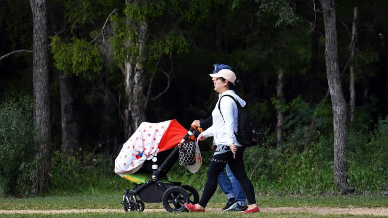 A young family walk through a park in Sydney on Sunday, April 30, 2017. (AAP Image/Paul Miller) NO ARCHIVING
