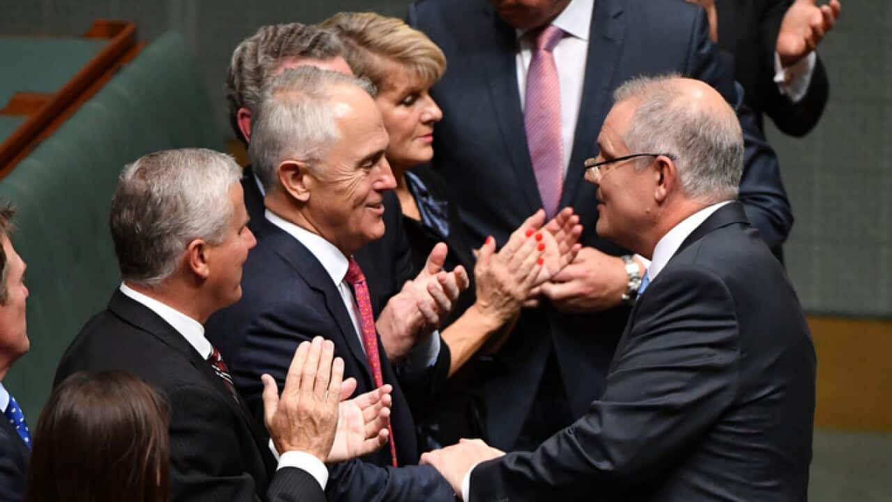 Prime Minister Malcolm Turnbull shakes hands with Treasurer Scott Morrison after delivering the 2018 Budget in the House of Representatives at Parliament House in Canberra, Tuesday, May 8, 2018. (AAP Image/Mick Tsikas) NO ARCHIVING