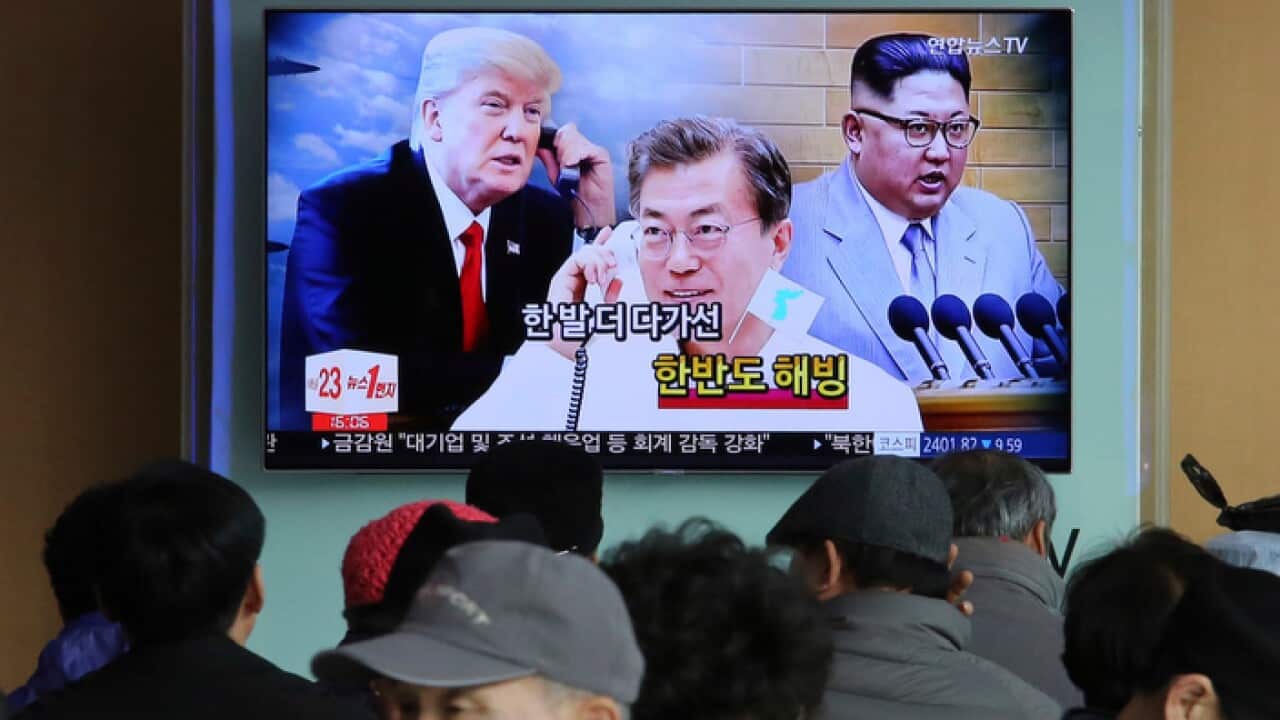 A TV screen showing images of North Korean leader Kim Jong Un, South Korean President Moon Jae-in and US President Donald Trump at Seoul Railway Station