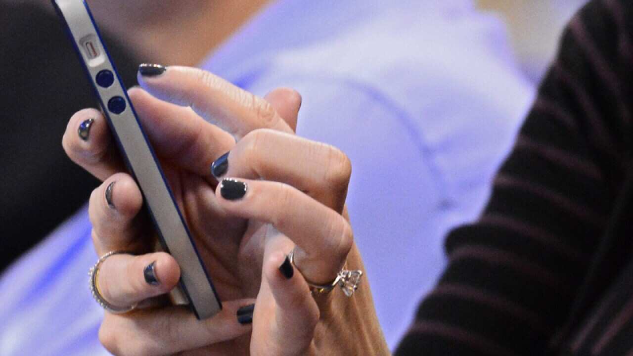 A woman uses her iPhone