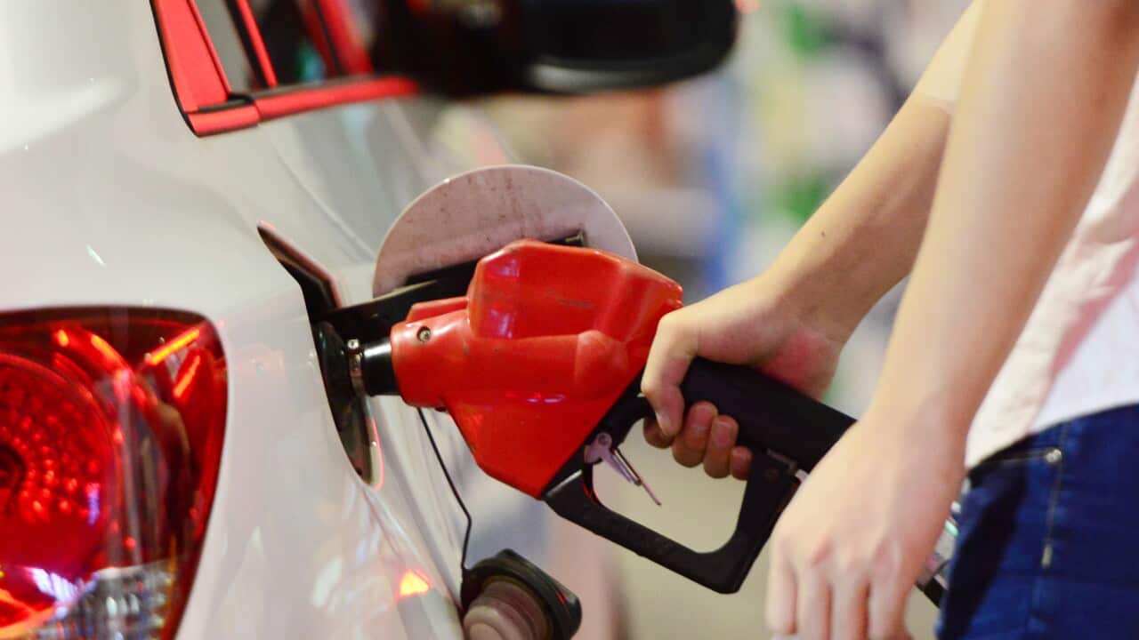 A person filling up their car with petrol at a service station