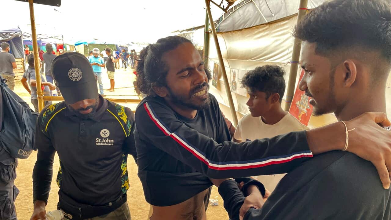 A man receives treatment from an ambulance worker following protests in Sri Lanka.