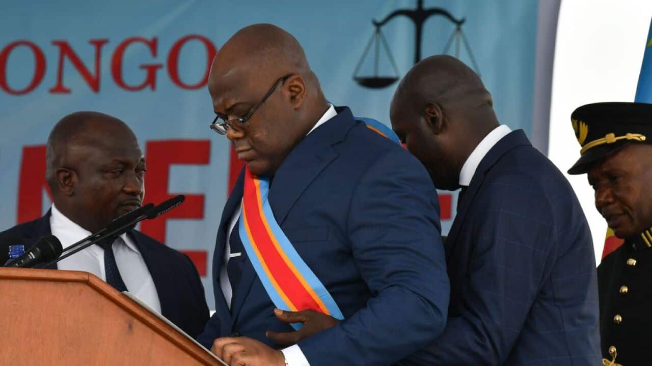 Democratic Republic of the Congo's newly inaugurated President Felix Tshisekedi is assisted by an aide