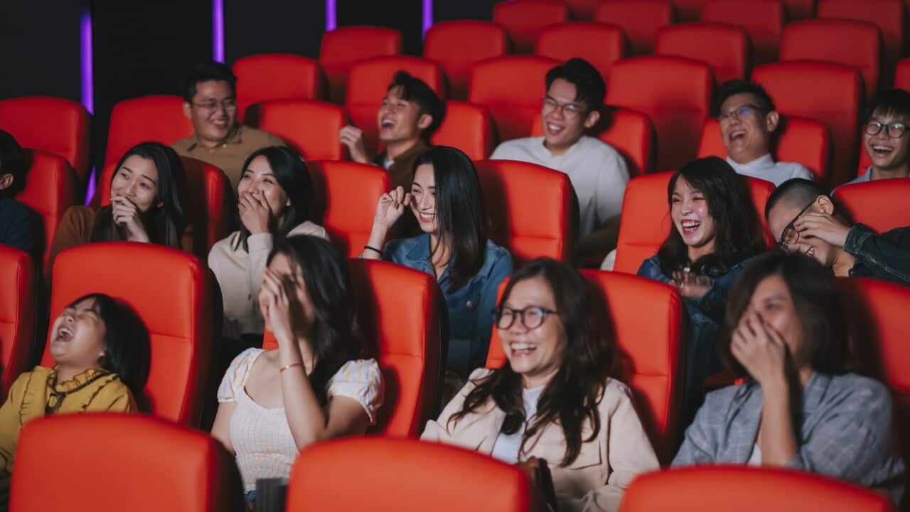 Audience watching comedy film and laughing in the cinema movie theater