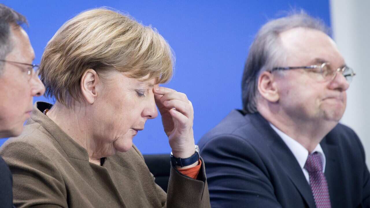 German chancellor Angela Merkel (C) reacting during a press conference after consultations on the ongoing migration situation in Germany