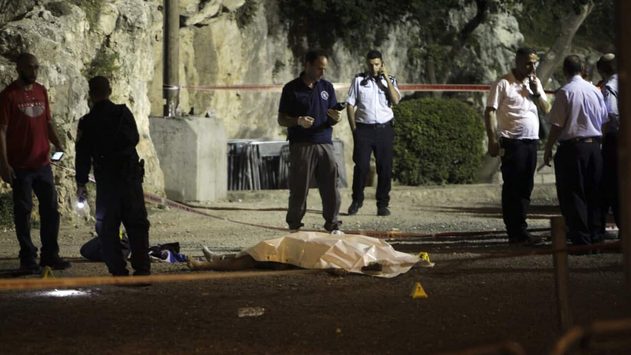 Israeli police stand around the body of a Palestinian shot dead in Jerusalem following a fatal attack on a policewoman.