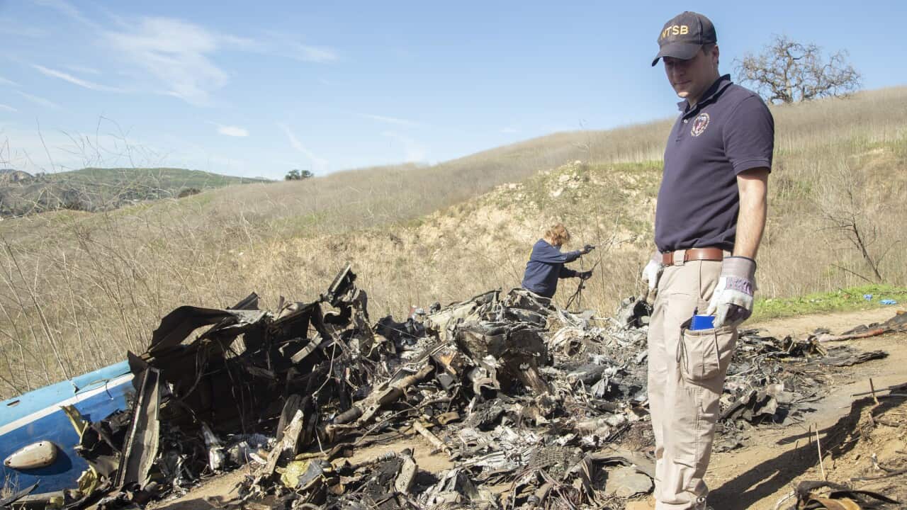 Crash investigators examine the wreckage of the Sikorsky S76B helicopter near Calabasas, California.