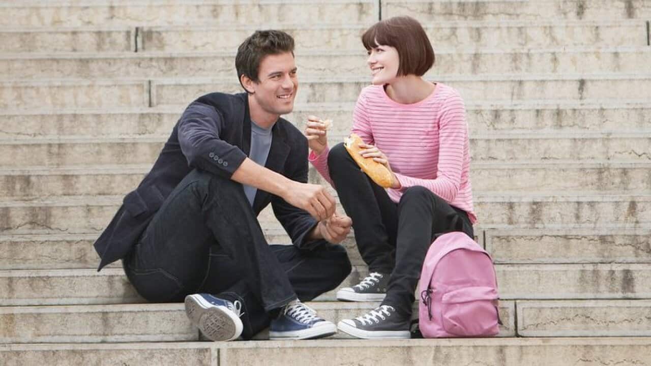 Young couple eating lunch sitting on stairway