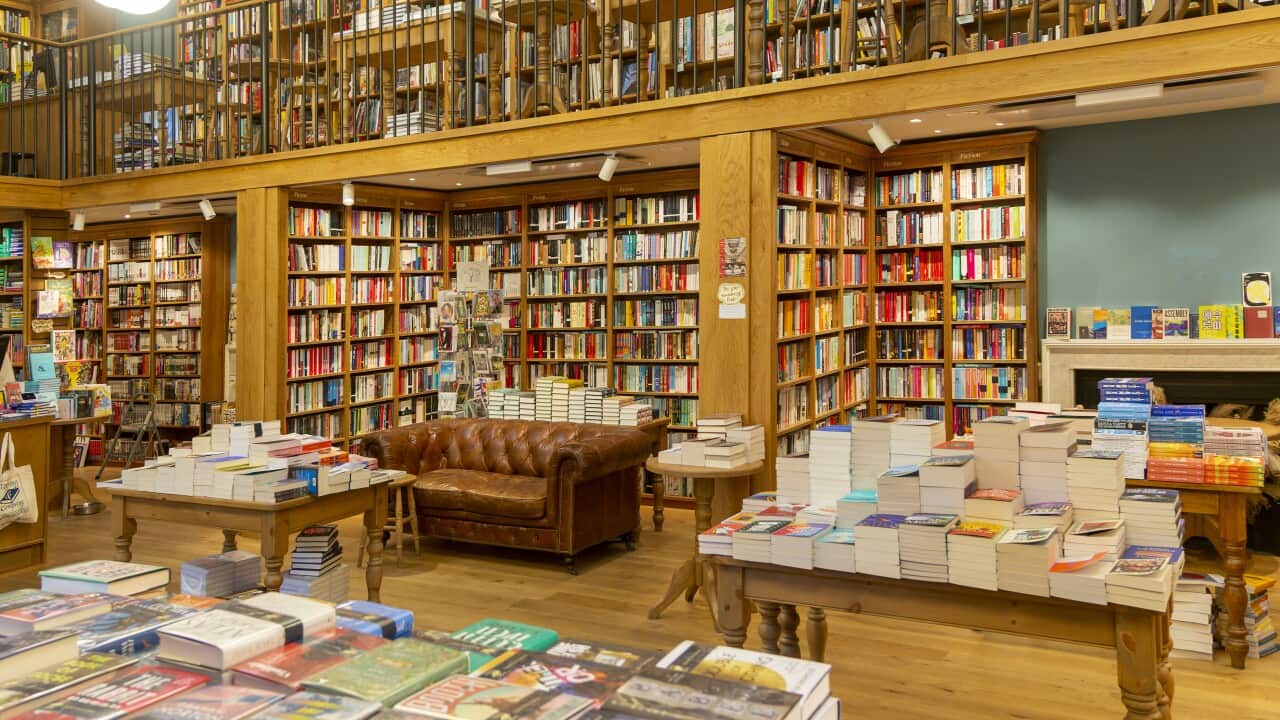 Books on shelves and tables in a bookstore.