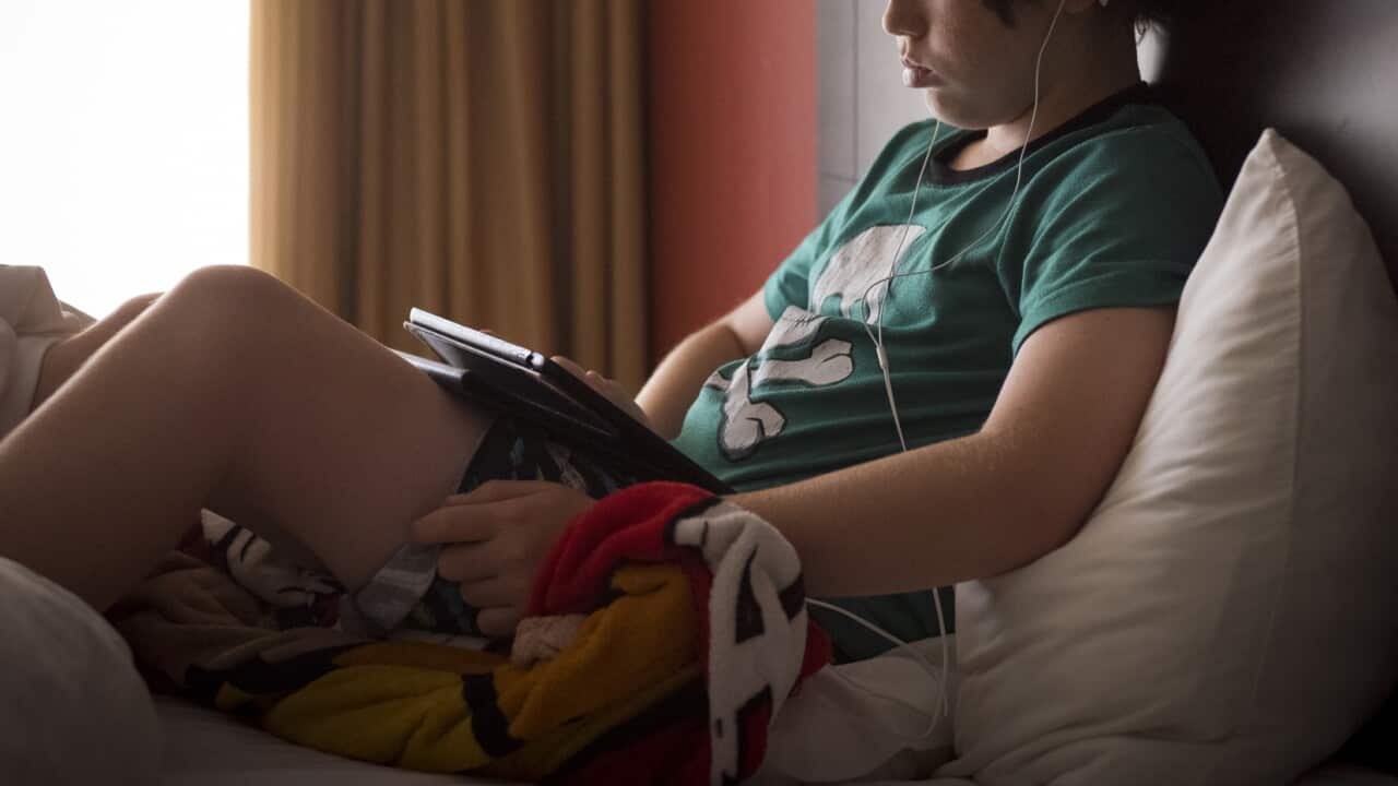 Boy watching, listening to video on device
