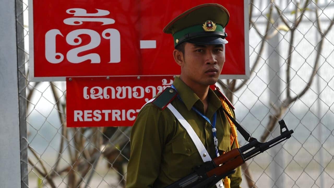 A Lao police stands guard (HOANG DINH NAM - AFP via Getty Images)