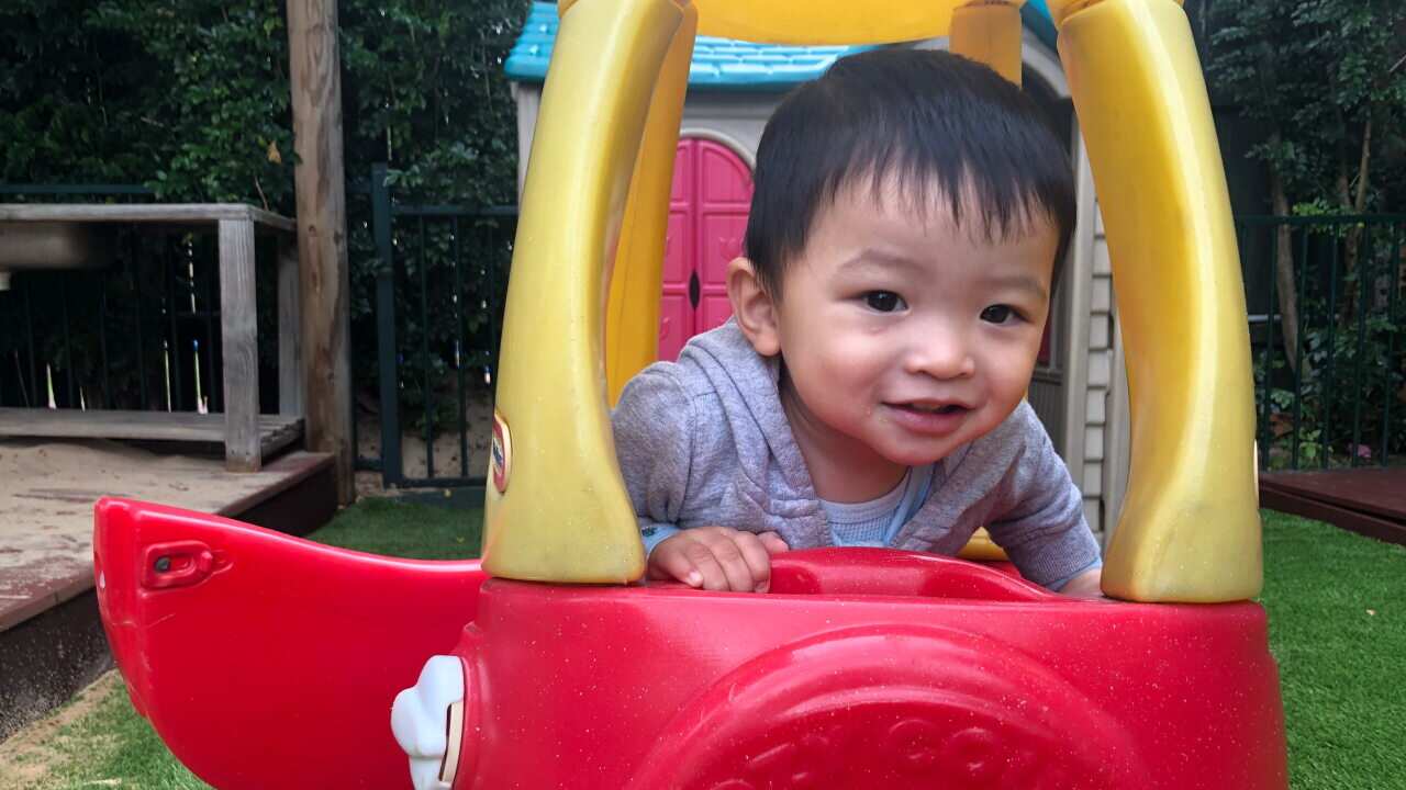A small boy plays in a toy car