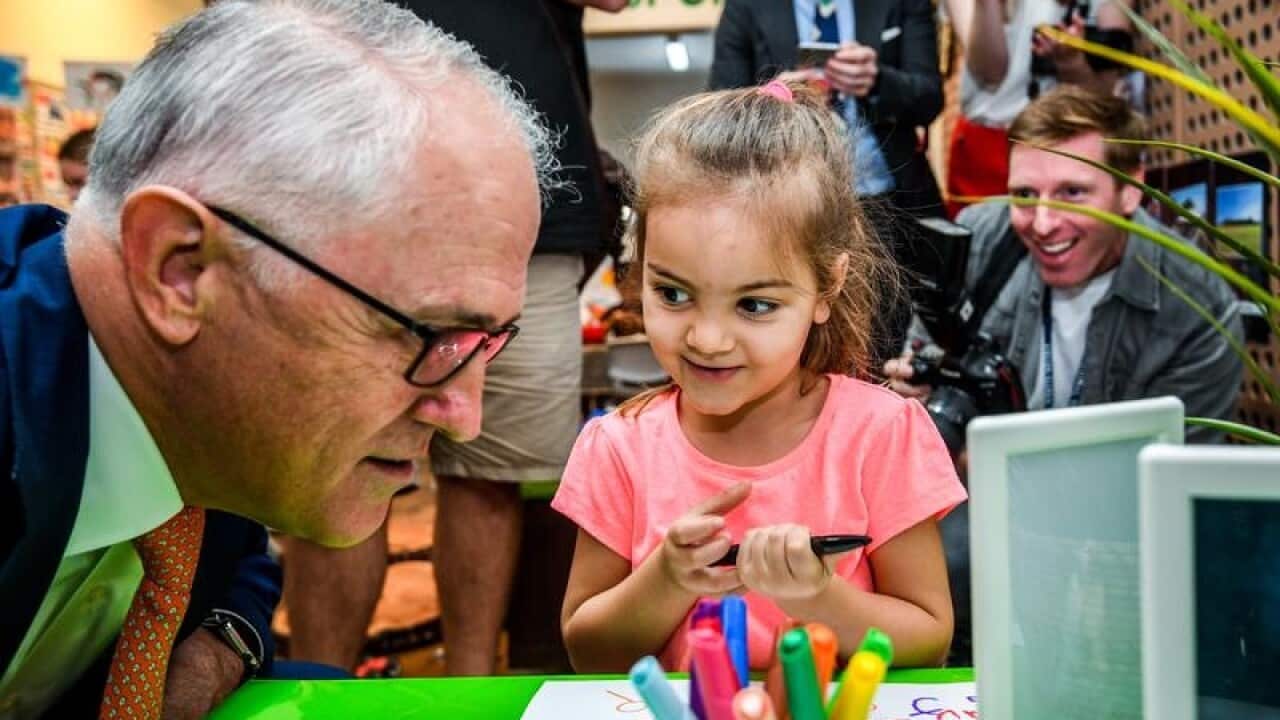 Australian PM Malcolm Turnbull inspects a child's drawing in Sydney.