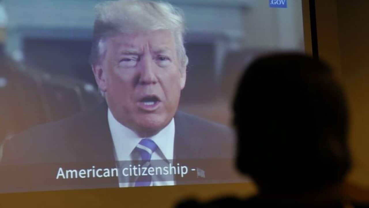 Maria Valles Bonilla watches a taped message from Donald Trump