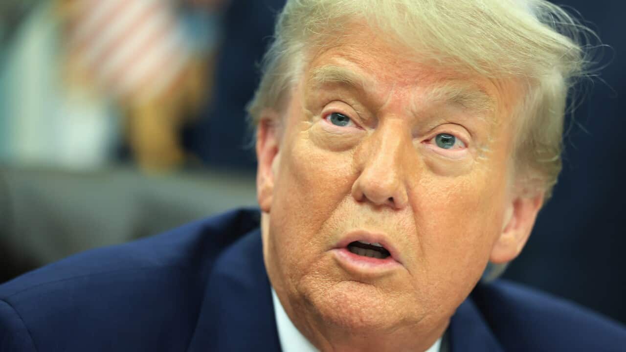 US President Donald Trump, who is wearing a suit and tie, is speaking.