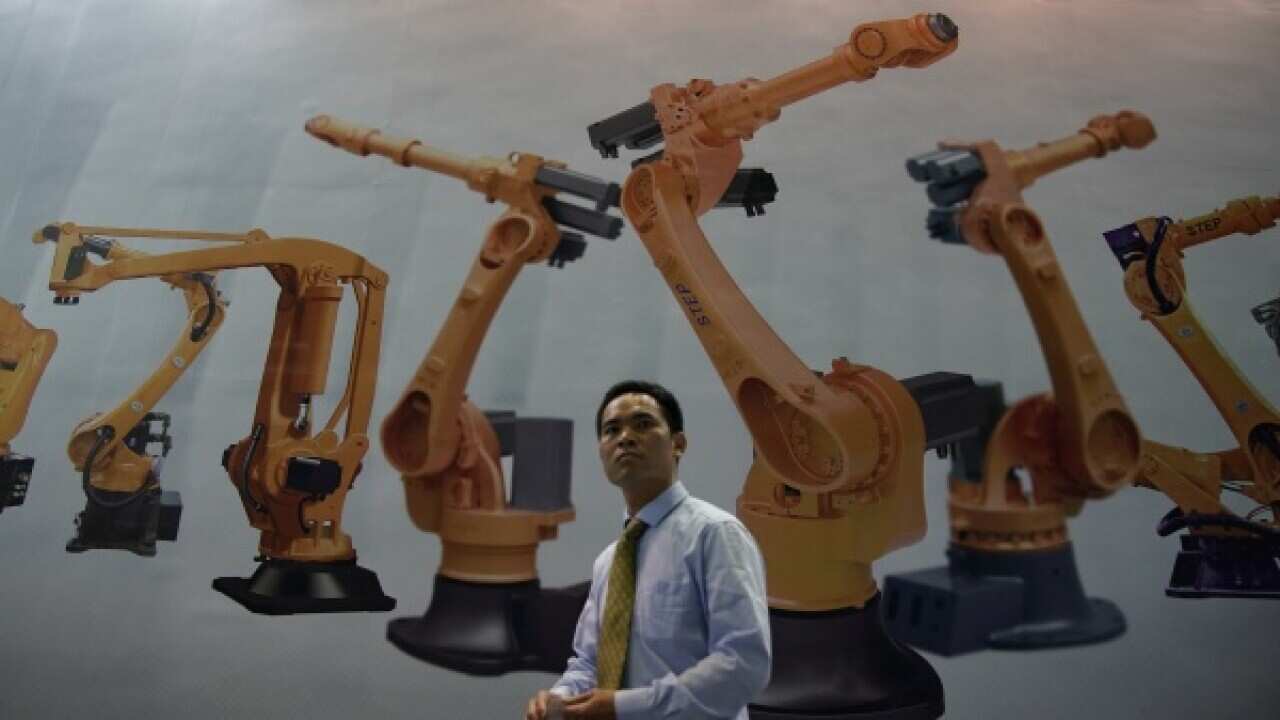 A man walks past a billboard at 2017 China International Robot Show in Shanghai