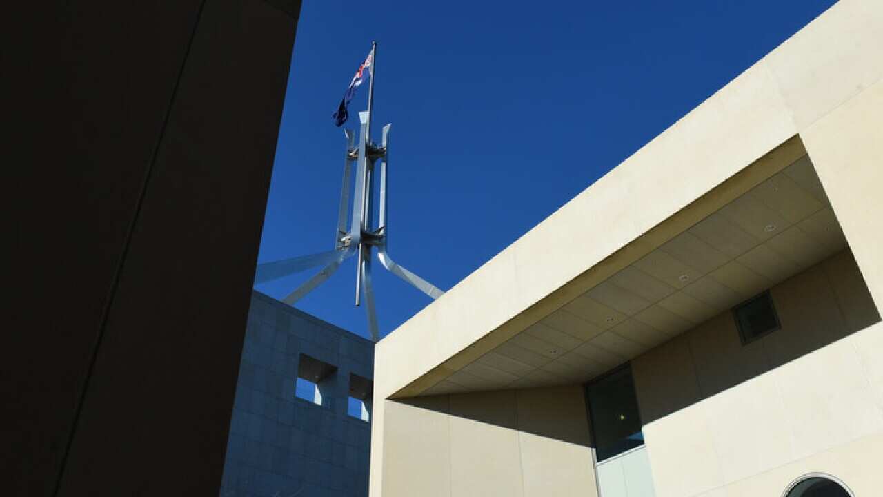 The Australian flag is seen above Parliament House in Canberra.