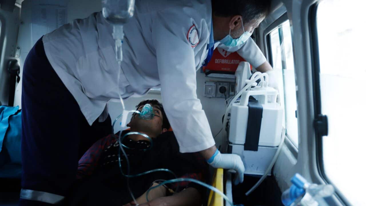 Afghan health workers carry a wounded person to a hospital after several mortars targeted a political gathering in downtown Kabul, Afghanistan.