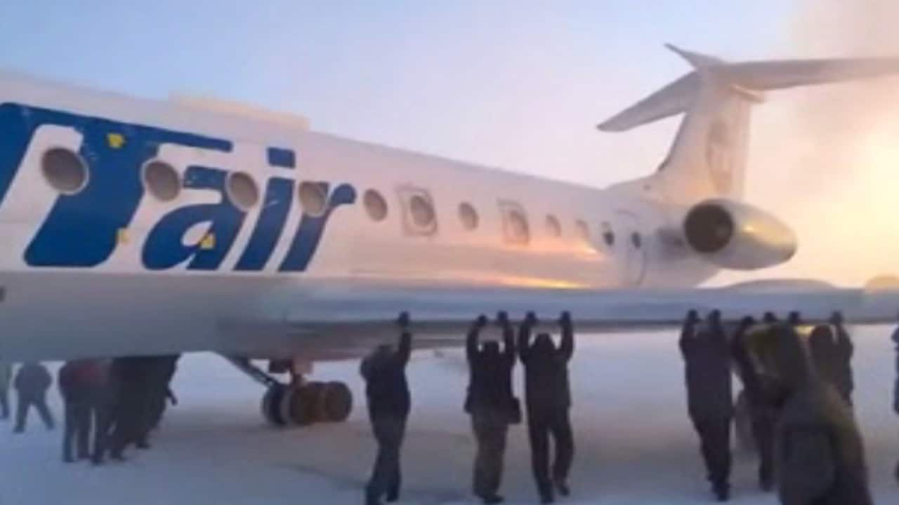 Passengers in Siberia had to get out an push their plane after its chassis became frozen. (Youtube)