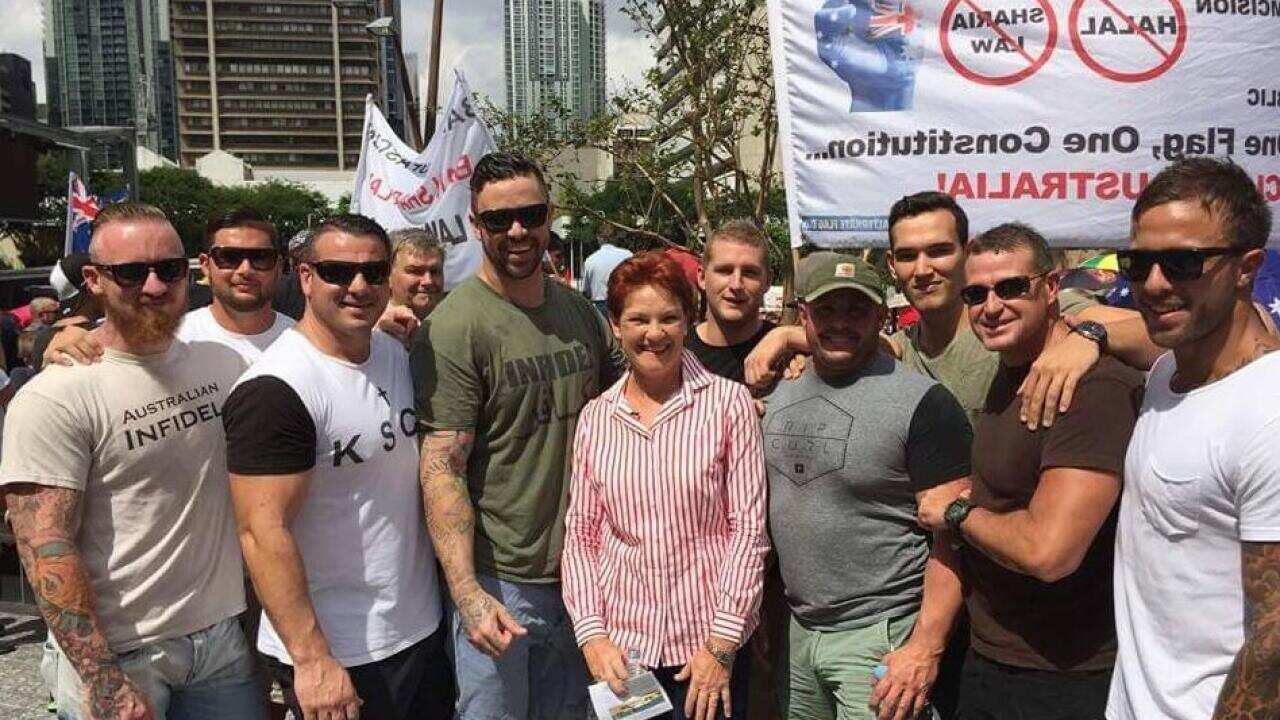 Eight Nauru detention staff suspended for taking a photo with controversial MP Pauline Hanson at the Brisbane Reclaim Australia rally. (Facebook/The Guardian)
