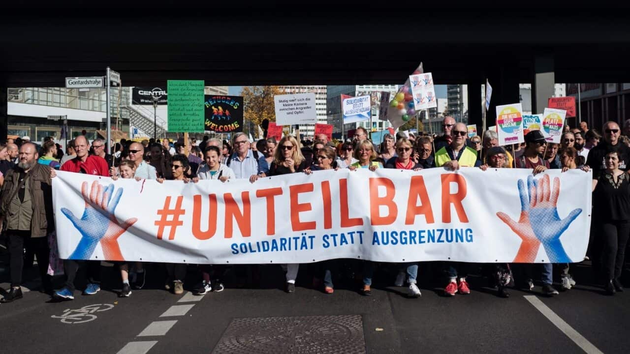 Demonstrators carry a banner reading '#indivisble' at a demonstration titled '#indivisible - solidarity instead of exclusion'