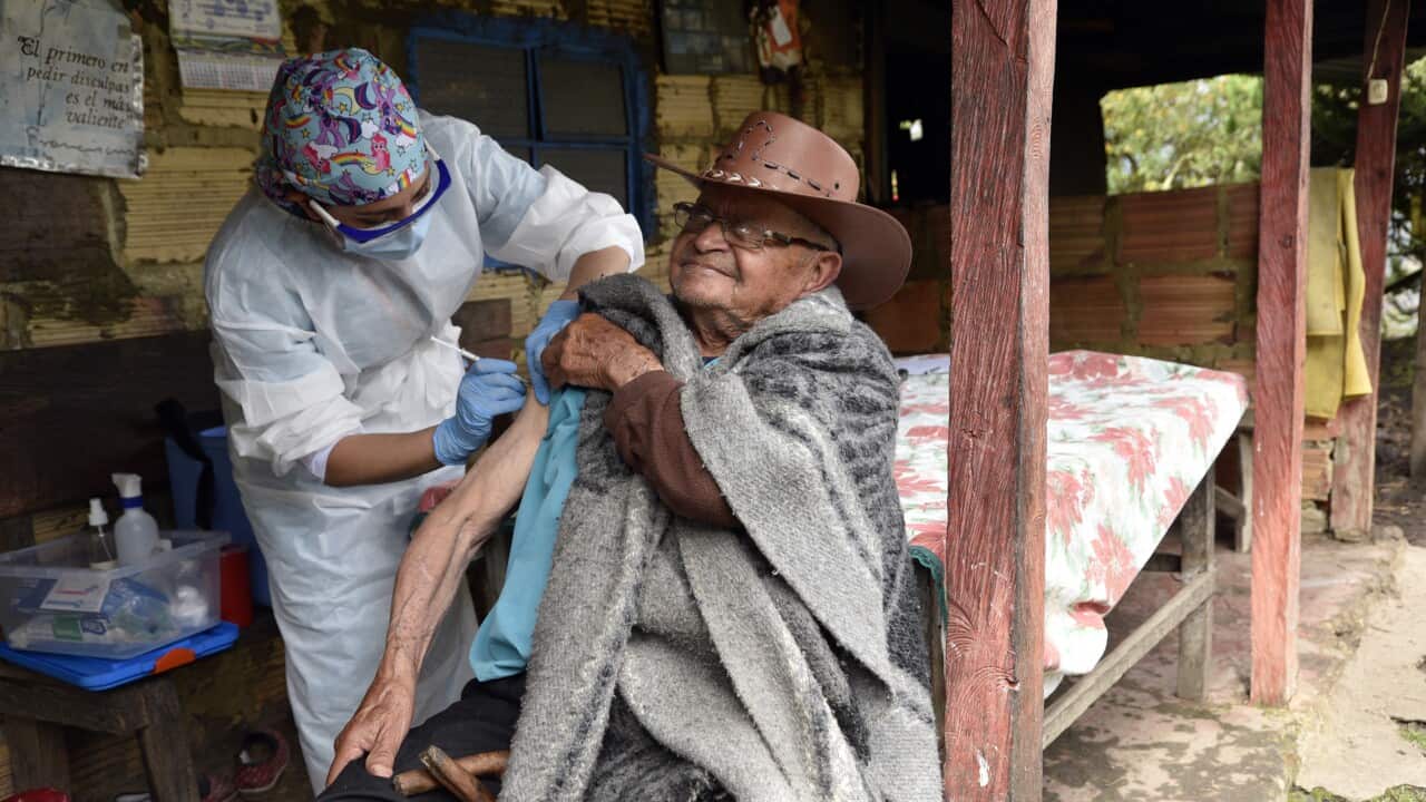 A nursing assistant gives a shot to an elderly man during a door-to-door vaccination campaign in rural areas of Bogota.