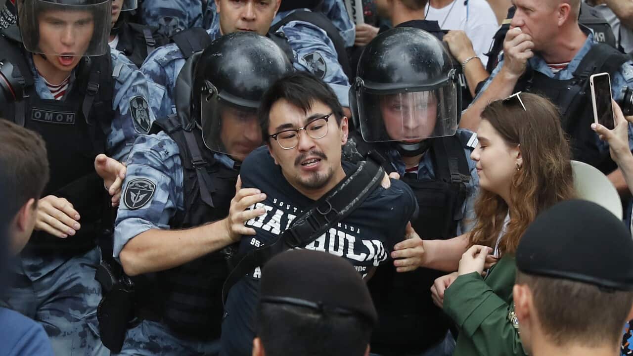 Police officers detain a protester during a march in Moscow, Russia, Wednesday, June 12, 2019.