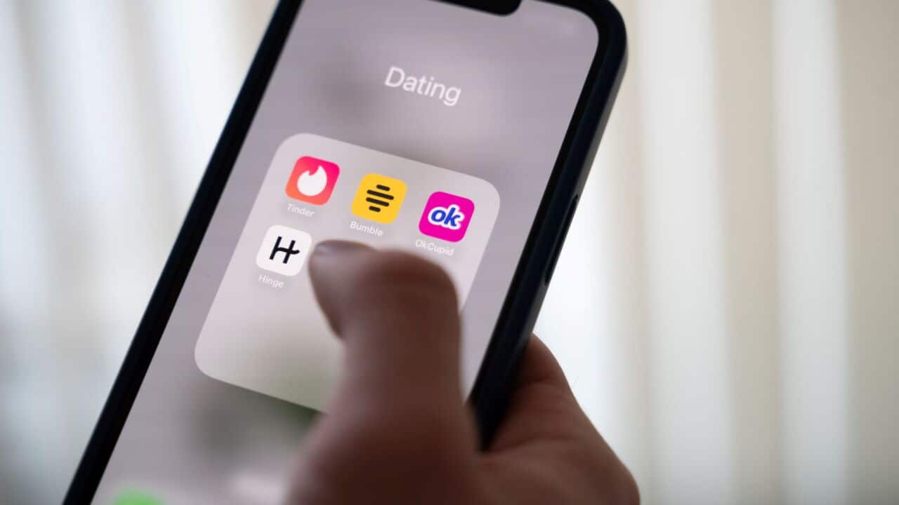 A woman holds a smartphone displaying dating apps (Alicia Windzio-dpa).jpg