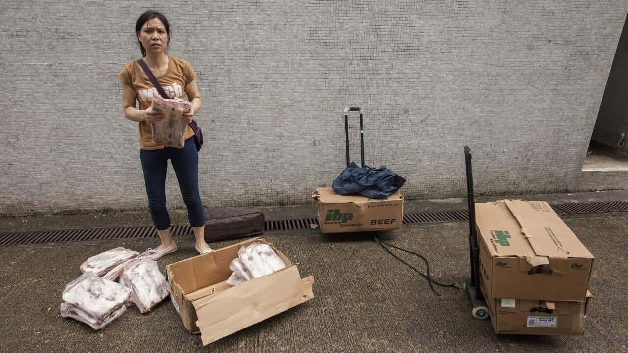 A woman holds a slab of frozen US beef short rib