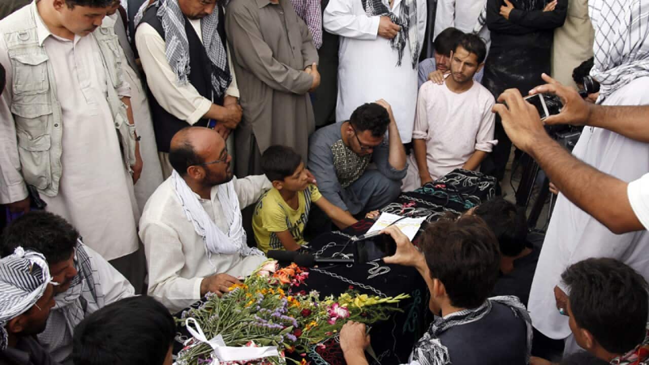 People attend the funeral of the victims of the suicide bomb attack