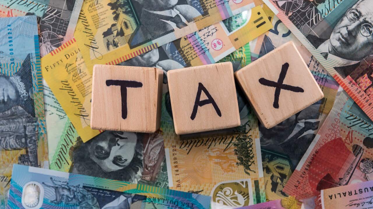 Wooden cubes with word 'Tax' on australian dollars